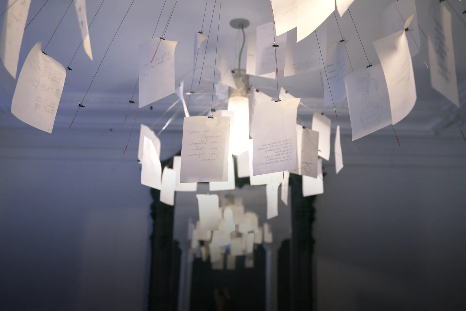 Lustre fait de feuilles de papier manuscrites suspendues